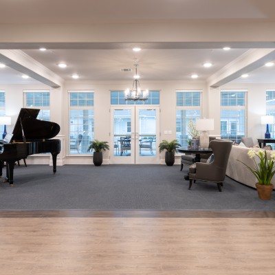large room with many windows and a grand piano